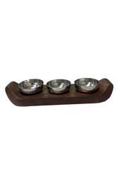 Three small metal bowls on a wooden stand against a plain background